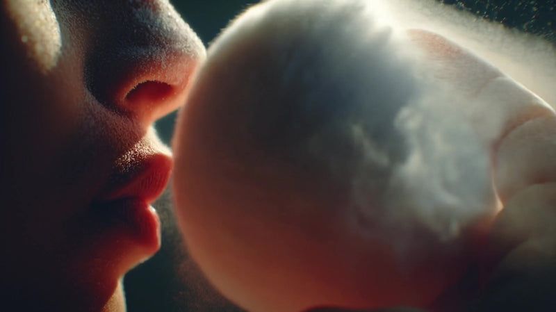 a person inhaling a cloud of powdered sugar with a close up view of their face and the sugar particles in mid air - Stock Video