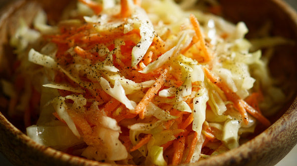 A Bowl Of Shredded Cabbage And Carrots In A Wooden Bowl With Seasoning Sprinkled On Top — Stock Photo