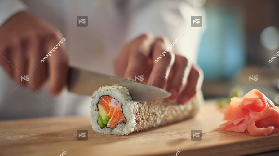 A Chef Preparing A Sushi Roll With A Knife And Ingredients On A Cutting Board — Stock Photo