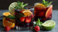 Two Glasses Of Sangria With Sliced Fruit And Mint Leaves On A Dark Surface — Stock Photo