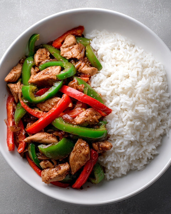 A Plate Of Chicken Stir Fry With Rice Served In A White Bowl On A Gray Surface — Stock Photo