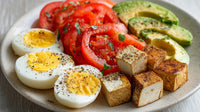 A Vibrant Breakfast Plate A Variety Of Foods Including Eggs Tomatoes Avocado Toast And Other Items — Stock Photo