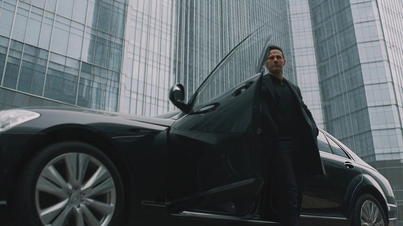 a composite of two separate photographs an urban setting and a man in a suit standing next to a black car - Stock Video