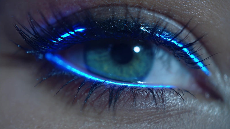 glowing blue eye makeup with a close up view of an eye showcasing the vibrant color and glowing effect against a dark background - Stock Video