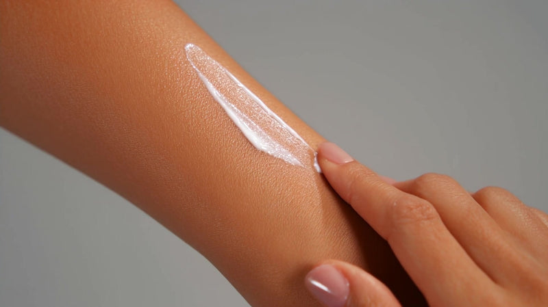 a hand applying a white substance lotion cream to an arm in a close up shot - Stock Video