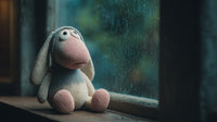 A Stuffed Bunny Sits By A Window During Rainfall With Droplets Visible On The Glass — Stock Photo