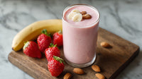 A Glass Of Strawberry Banana Smoothie Garnished With Nuts Placed On A Wooden Surface Next To Fresh Strawberries And Bananas — Stock Photo