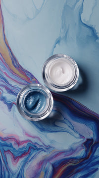 Displays Two Clear Glass Jars With Blue Nail Polish On A Surface That Has A Marbled Pattern Resembling Water Paint — Stock Photo