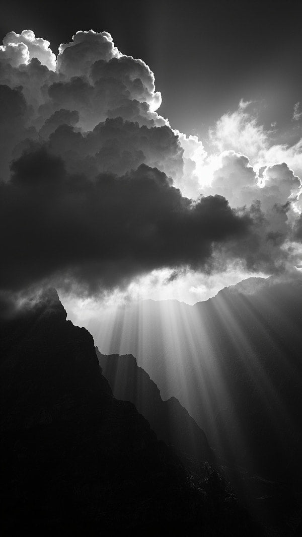 A Black And White Photograph Captures A Sunbeam Piercing Through Clouds Casting A Striking Contrast Against The Dark Sky — Stock Photo
