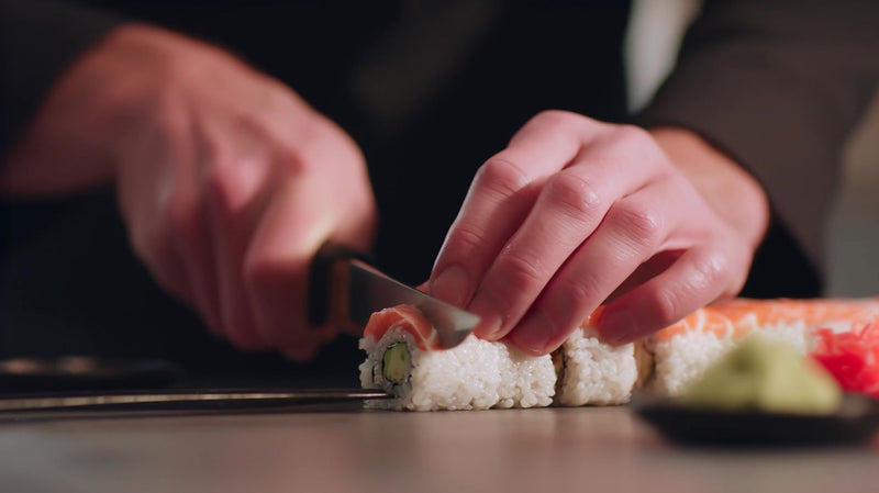 in a bustling restaurant kitchen a chef meticulously prepares sushi rolls on a countertop - Stock Video