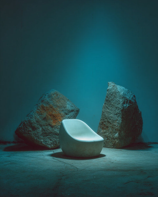 Art Installation In A Dimly Lit Room A White Chair And Large Rocks As Backdrop — Stock Photo