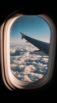 An Airplane Window View From An Airplane Seat Showcasing A Clear Blue Sky And Clouds Below — Stock Photo