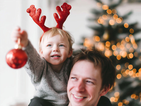 A Family Holiday Celebration With A Baby Wearing A Reindeer Hat And Holding A Christmas Ornament — Stock Photo