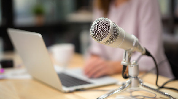 Professional Podcasting Setup With A Woman Speaking Into A Microphone Sitting At A Table With A Laptop And A Cup — Stock Photo