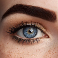 Close Up Of A Person S Eye With Blue Iris And Freckles Showcasing Makeup And Eyelashes Against A Neutral Background — Stock Photo