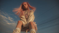 A Young Woman With Pink Hair Sitting On A Power Line Wearing A Yellow Jacket And Holding Onto Her Legs — Stock Photo