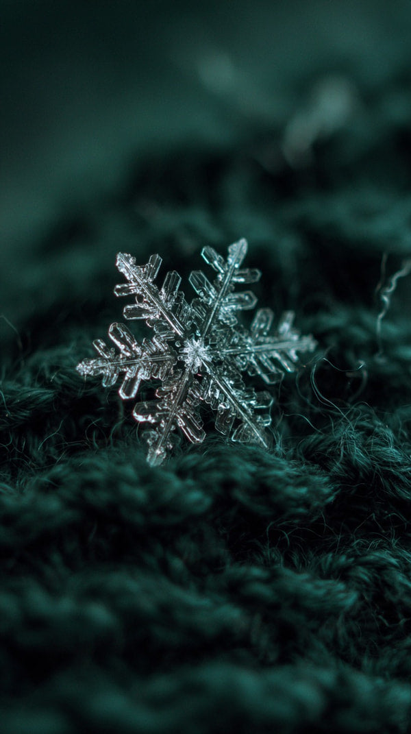 A Single Intricately Detailed Silver Snowflake Against A Dark Green Textured Fabric Backdrop — Stock Photo