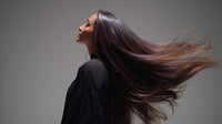 woman with long hair captured in a close up shot from behind showcasing her flowing locks after a blowout - Stock Video