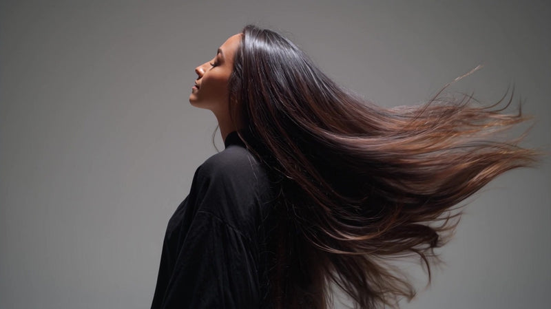 woman with long hair captured in a close up shot from behind showcasing her flowing locks after a blowout - Stock Video