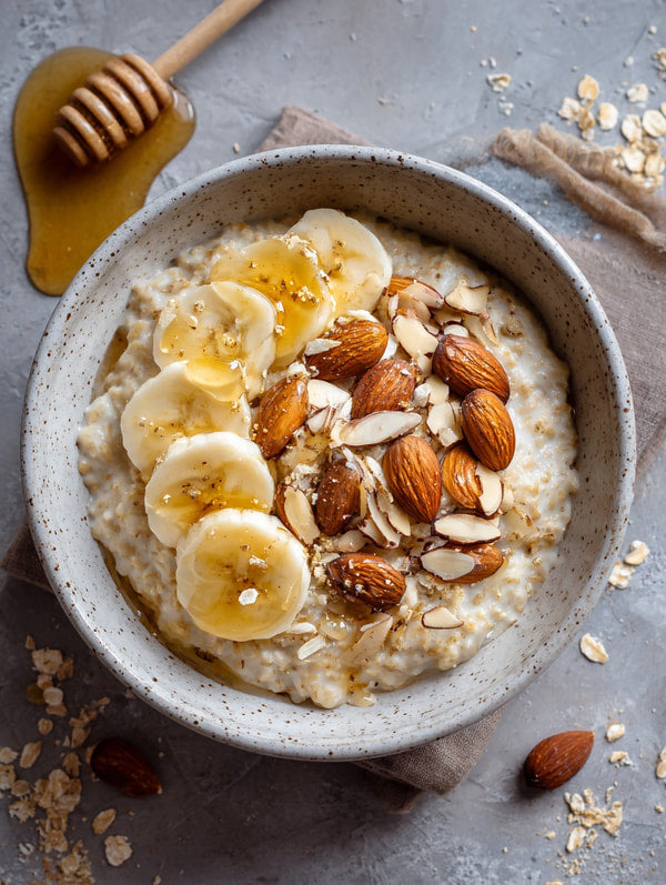 Overnight Oats Topped With Banana Slices Almonds And Honey In A Bowl On A Table — Stock Photo