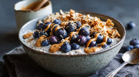 A Bowl Of Blueberries And Coconut Yogurt Topped With Honey Placed On A Table — Stock Photo