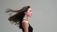 a woman with long hair is captured in a portrait style image set against a white background - Stock Video