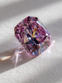 A Large Round Purple Diamond Ring With A Sparkling Surface And Multiple Facets Set Against A White Background On A Table — Stock Photo