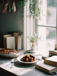 A Cozy Kitchen Scene With A Plate Of Food On The Table And Books In The Background — Stock Photo