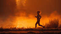 A Woman Running At Sunset With A Backdrop Of Misty Water And A Clear Sky — Stock Photo