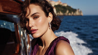 A Woman Posing For A Portrait By The Ocean Wearing A Purple Dress And Earrings — Stock Photo