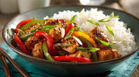 A Plate Of Chinese Chicken Stir Fry With Rice Garnished With Red Peppers And Green Onions Served In A Blue Bowl — Stock Photo
