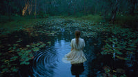A Solitary Individual Wading Through A Swampy Area Surrounded By Lily Pads And Vegetation With A Serene Backdrop Of A Night Sky — Stock Photo