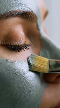 a woman receiving a facial spa treatment with a focus on the application of a face mask using a brush - Stock Video