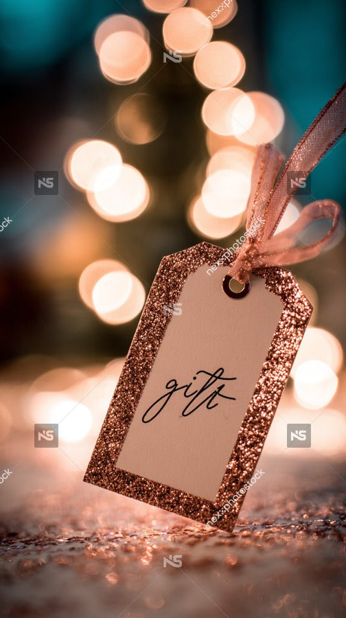 A Festive Christmas Gift Tag With A Glittery Background And A Joy Message Placed On A Table Adorned With Twinkling Lights — Stock Photo