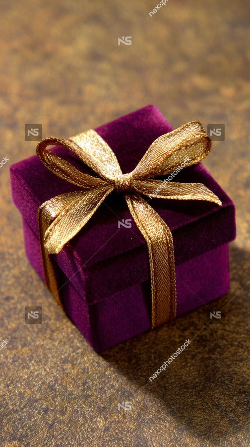 A Purple Gift Box With A Gold Ribbon Placed On A Surface — Stock Photo