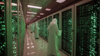 Data Center Worker Amidst Green Server Racks — Stock Photo
