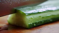a close up image of a celery stalk resting on a cutting board with a knife visible in the background - Stock Video