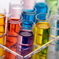 Colorful Beakers In A Laboratory Setting Showcasing A Variety Of Colors And Shapes Within Clear Glass Beakers Displayed On A Tray — Stock Photo