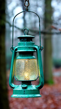 Green Antique Lantern Hanging From Chain In Forest Setting With Light Glowing Through Glass Panels — Stock Photo