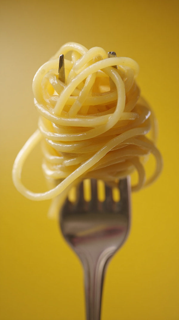 A Fork With Spaghetti On It Placed Against A Yellow Background — Stock Photo