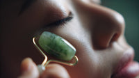 a woman in a close up shot with her eyes closed holding a jade stone to her face - Stock Video