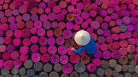 A Vendor Stands Amidst Stacks Of Colorful Wood Surrounded By A Vibrant Array Of Pink And Purple Logs — Stock Photo