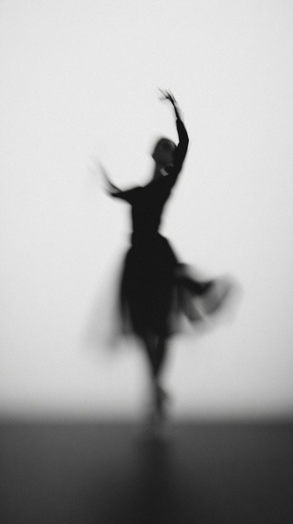 Ballerina Silhouette Against A White Background Captured From A Side Angle Performing A Ballet Pose With One Leg Extended Behind Her — Stock Photo