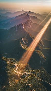 majestic mountain range under a sunset with the peaks bathed in warm hues and the sky transitioning from orange to blue - Stock Video