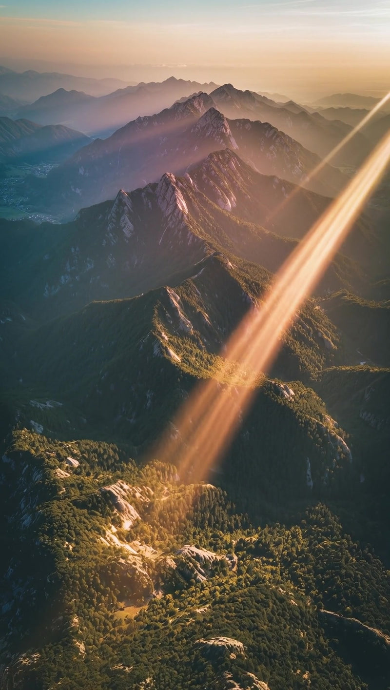 majestic mountain range under a sunset with the peaks bathed in warm hues and the sky transitioning from orange to blue - Stock Video